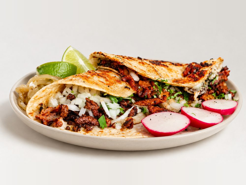 El Taco Veloz tacos with onion, cilantro, lime, and sliced radish