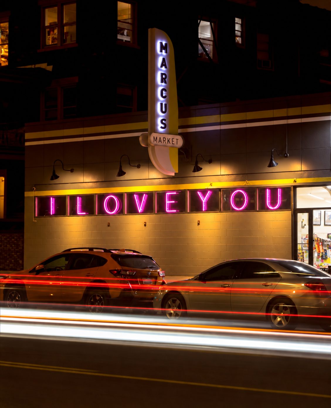 Marcus Market at night with its vertical MARCUS sign and pink I LOVE YOU neon